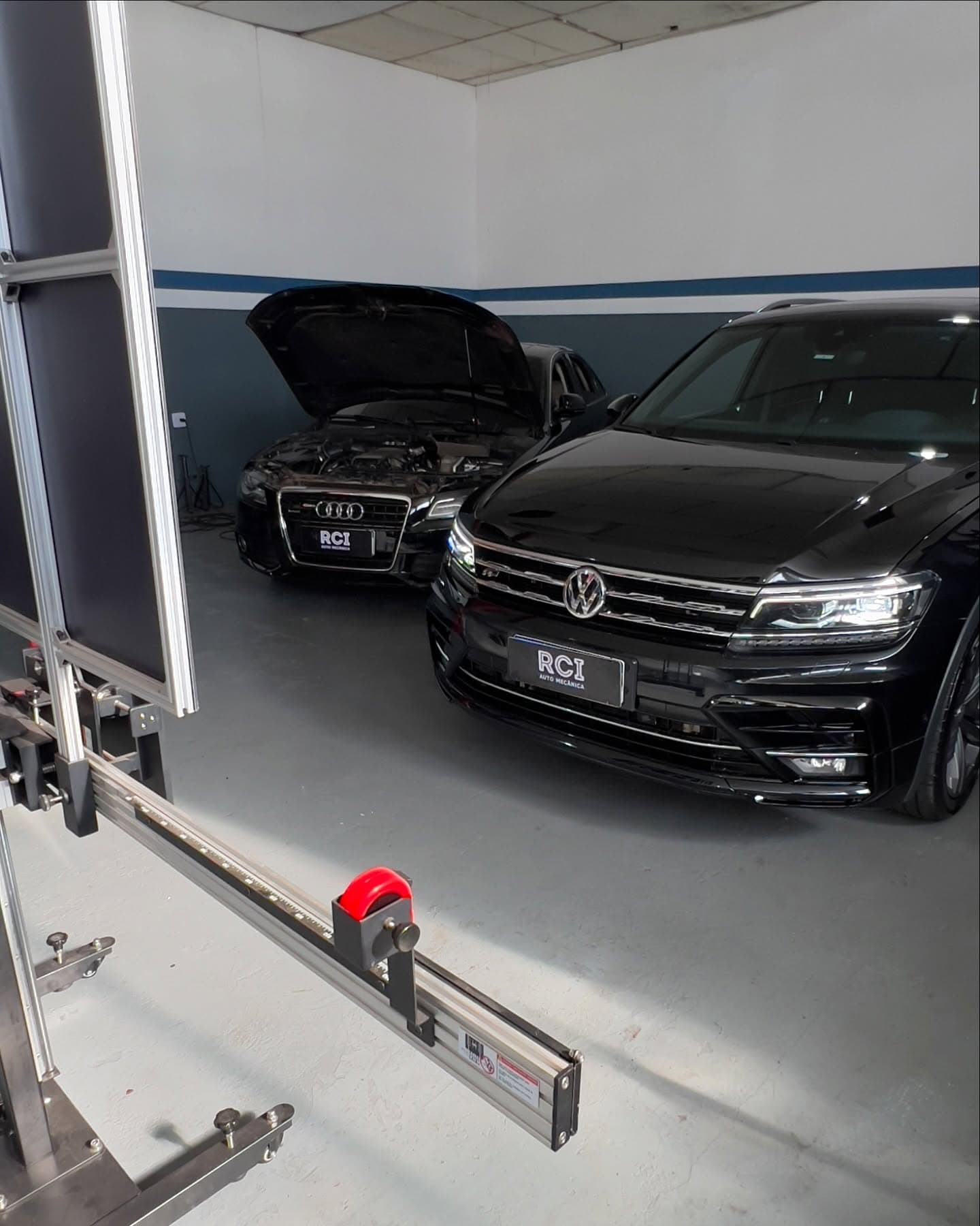 Estrutura de calibração ADAS em frente a um Tiguan e um Audi pretos